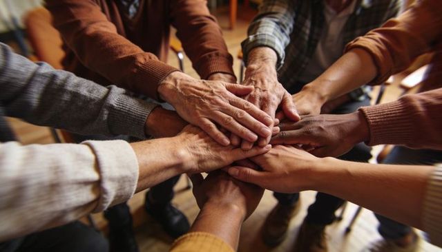 Senior Hands Joining in Supportive Circle Showing Unity and Community Care