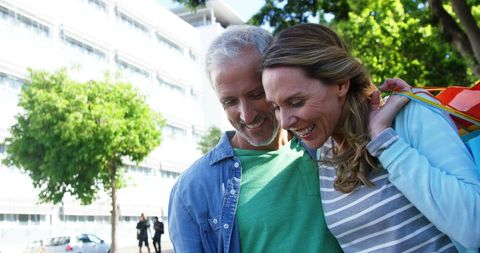 Happy Mature Couple Enjoying Smartphone Outdoors