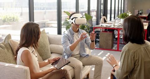 Coworkers Collaborating with Virtual Reality in Modern Office Common Area
