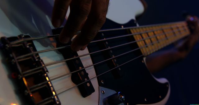 Close-up of a musician playing an electric guitar on stage. Fingers on strings capture the essence of a live music performance.