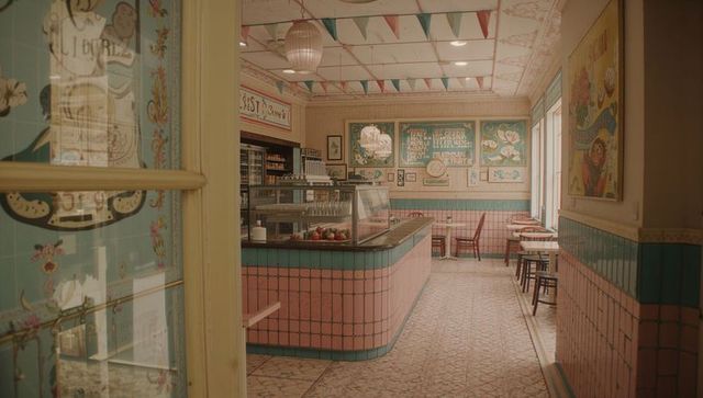 Retro pastel ice cream parlor interior featuring curved tiled counter and dessert display