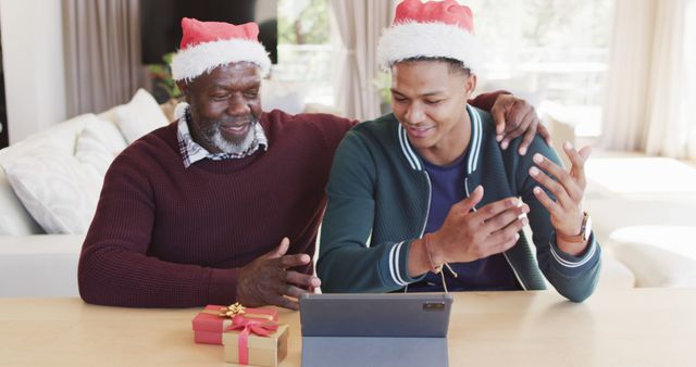 Happy african american father and adult son in christmas hats having tablet image call - Download Free Stock Photos Pikwizard.com