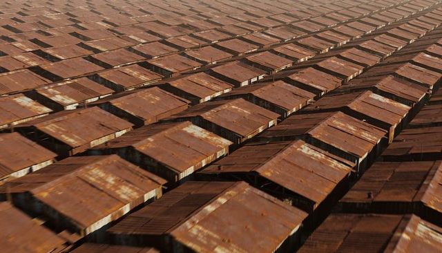 Rusting corrugated metal roofs in diagonal rows with weathered patina and repeating industrial patte