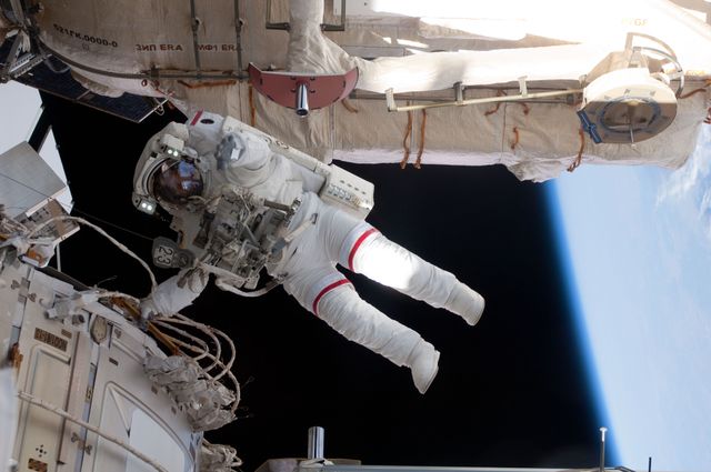 Astronaut Andrew Feustel, in full space suit, is performing a spacewalk, also known as an extravehicular activity (EVA), during the STS-134 mission on the International Space Station. He is hovering outside the station with the Earth visible in the background. This image can be used for topics related to space exploration, NASA missions, astronauts working in space, and the technical and human aspects of maintaining and operating space infrastructure.