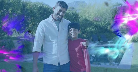 Father embracing son in backyard poolside portrait smiling with colorful light overlays