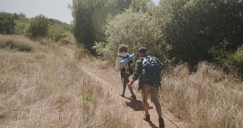 Couple Enjoying a Hiking Adventure in Sunlit Nature