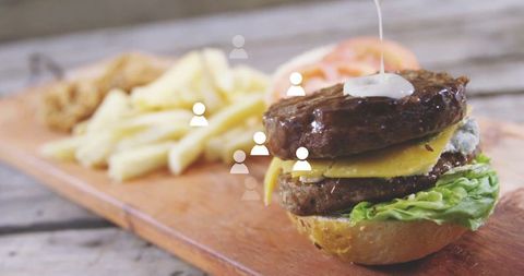 Gourmet double cheeseburger with fries on wooden platter