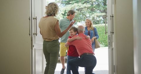 Joyful Grandparents Welcoming Family at Front Door of Home