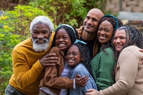 Multigenerational family hugging and smiling in backyard garden warmth and togetherness