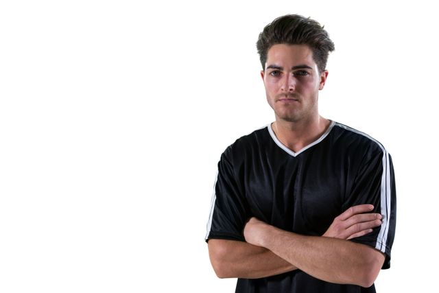 Portrait of football player standing with arms crossed against white background
