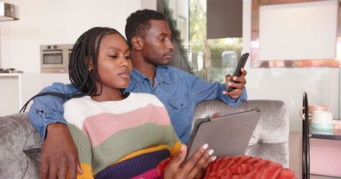 Modern Couple Relaxing with Devices in Contemporary Living Room