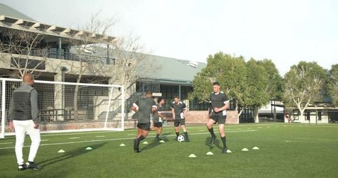 Coach leading diverse soccer team in intense training session