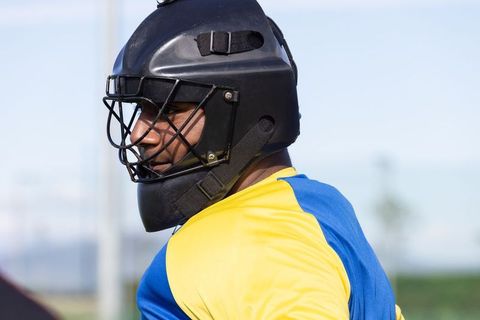Catcher in colorful gear on scenic baseball field