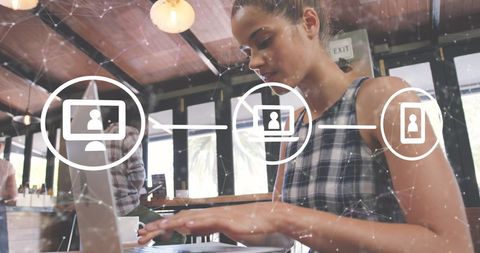 Woman engaging with digital network on laptop in modern café