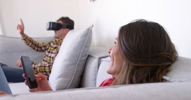 Couple Enjoying Virtual Reality and Smartphone on Sofa - Download Free Stock Images Pikwizard.com