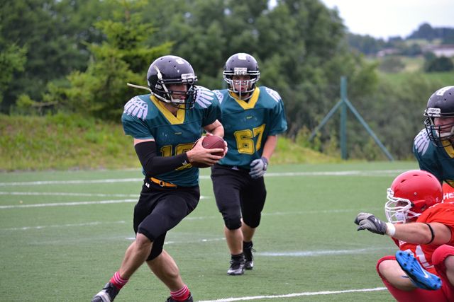 Football players in an intense moment during a game, wearing protective gear and running with a football. Ideal for use in sports marketing, promoting football events, illustrating teamwork and athleticism in brochures, or enhancing sports-focused articles and blogs.