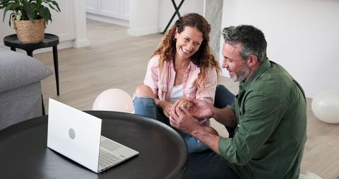 Couple celebrating engagement with online video call at home