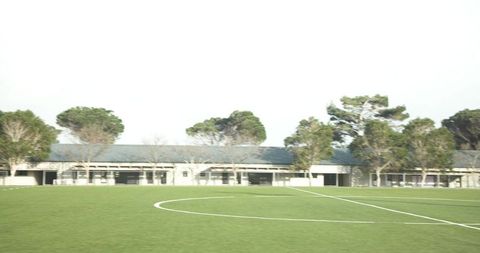 Empty School Soccer Field With Trees and Blue Sky