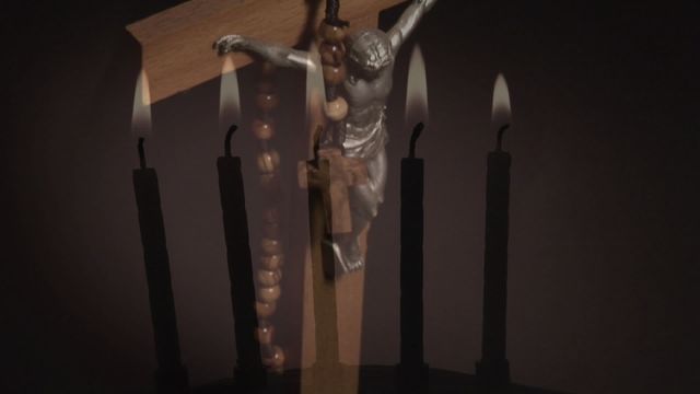 This image features a crucifix against burning candles, evoking themes of spiritual reflection and prayer. It can enhance religious-themed websites, materials, or presentations.