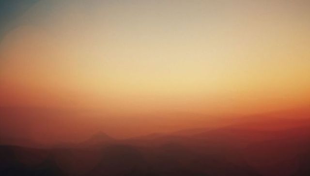 Ethereal Dawn with Misty Mountains and Glowing Golden Sky