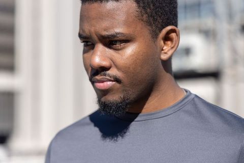 African american man gazing thoughtfully in urban sunlight headshot professional portrait