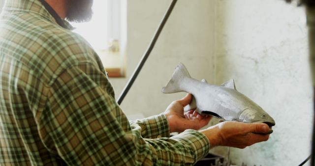 Craftsman examining fish sculpture in workshop 4k