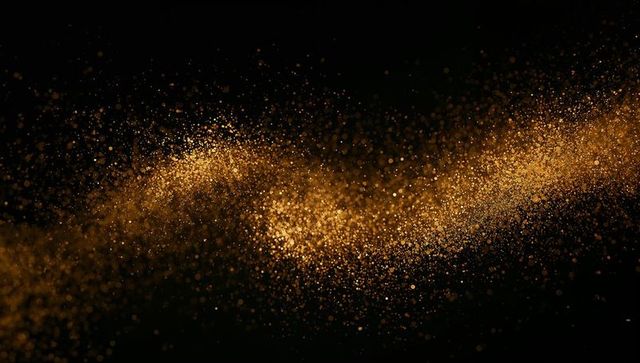 Flowing golden particle ribbon on black background