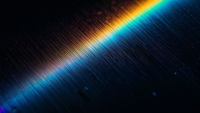 Luminous diagonal beam cutting across brushed metal with cyan teal gradient and bokeh