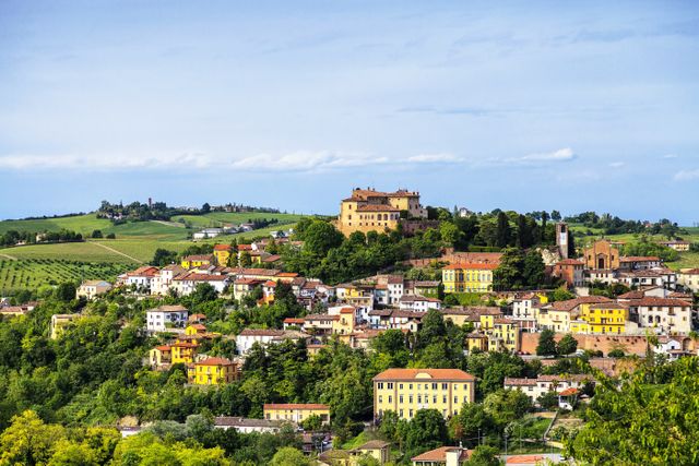 This scene captures a charming Italian village nestled on green hills with an array of colorful houses. Use this image for projects related to travel, tourism, culture, European destinations, or rural lifestyle. Ideal for websites, brochures, and other promotional materials highlighting beautiful landscapes and travel inspiration.