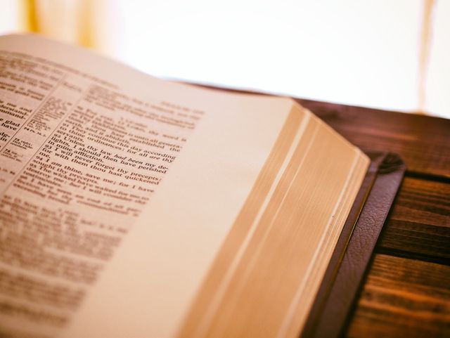 Close-Up of an Open Bible on Wooden Table - Download Free Stock Photos Pikwizard.com