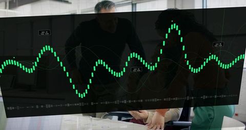 Team analyzing green candlestick dashboard overlay on tablet in modern office collaboration