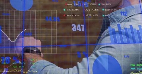 Professional pointing at interactive digital dashboard analyzing metrics wearing smartwatch