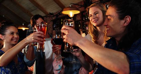 Young Adults Toasting Drinks in Cozy Bar Celebration - Download Free Stock Images Pikwizard.com