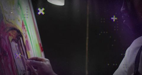 Artist in apron painting on canvas with digital overlays