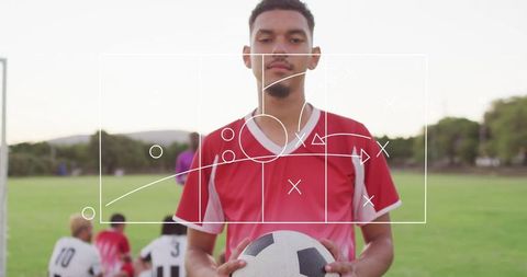 Focused Soccer Player Holding Ball with Strategic Overlay on Field