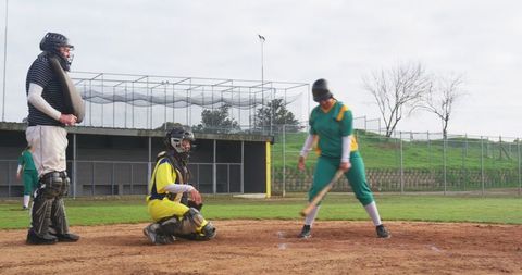 Baseball Players Ready at Home Plate with Umpire Observing