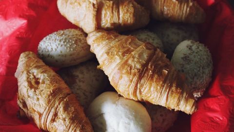 Assortment of Fresh Croissants and Bread Rolls in Basket
