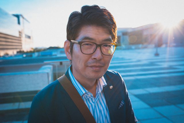 Portrait of asian man wearing glasses standing at the terrace of corporate park. business and lifestyle concept