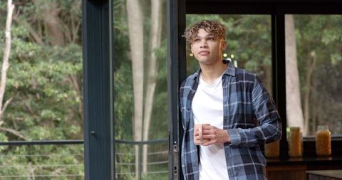 Young Man Relaxing with Coffee in Rustic Forest Environment