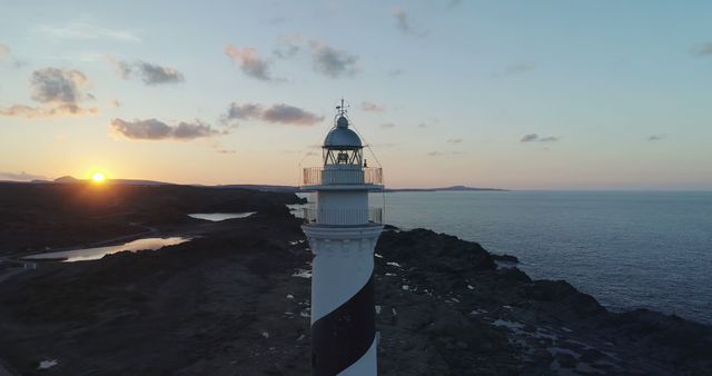 Aerial View of Black and White Striped Lighthouse at Sunset by Rocky Coastline - Download Free Stock Images Pikwizard.com