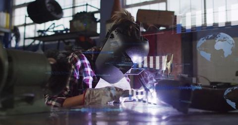 Female welder performing tig welding with ar hud overlay in industrial workshop