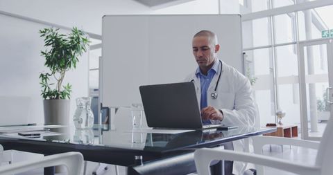 Focused Doctor Working on Laptop in Modern Hospital Office