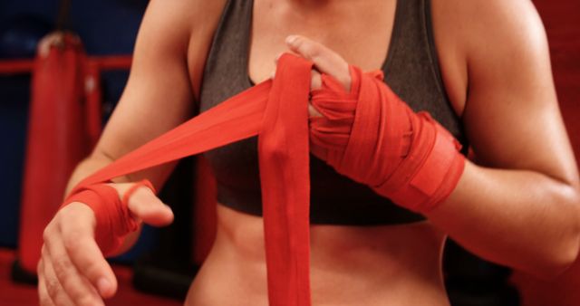 Female Athlete Wrapping Hands with Red Bandages in Gym - Download Free Stock Images Pikwizard.com