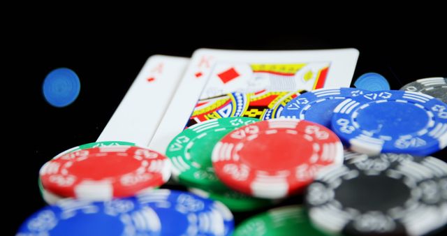 Close-up showing colorful poker chips and playing cards, emphasizing a gambling theme. Ideal for use in articles, blogs, and promotional materials related to casinos, gaming strategies, or online poker games. Perfect for illustrating high-stakes situations in marketing campaigns or entertainment industry features.