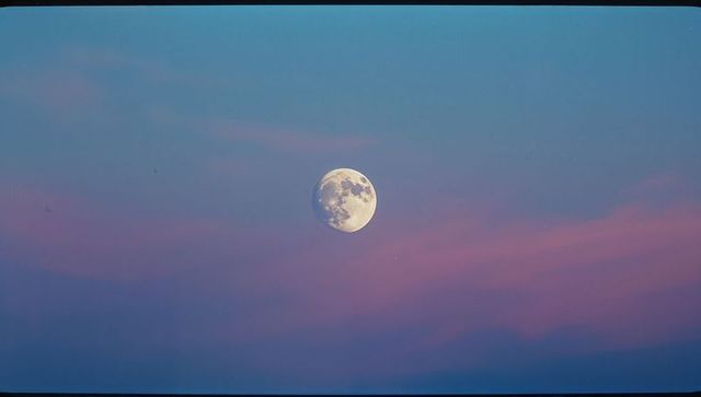Serene Nearly Full Moon Illuminated in Twilight Sky