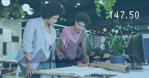 Business Colleagues Analyzing Financial Graphs in Modern Office