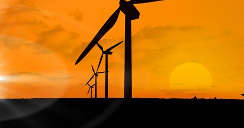 Silhouetted Wind Turbines with Plane Against Orange Sunset - Download Free Stock Images Pikwizard.com