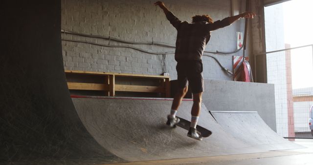 Young Man Doing Tricks on Skateboard at Indoor Skatepark - Download Free Stock Images Pikwizard.com