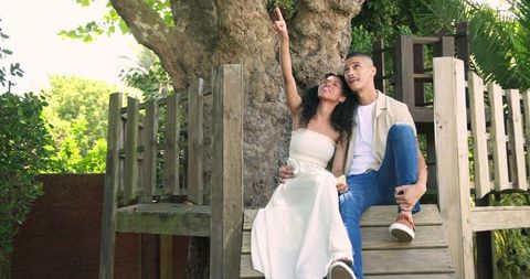 Couple Relaxing on Wooden Platform in Lush Garden