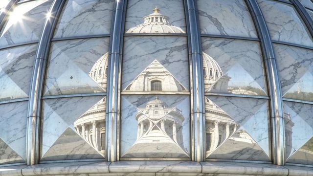 Reflecting classical dome in curved glass facade showing geometric marble fragments